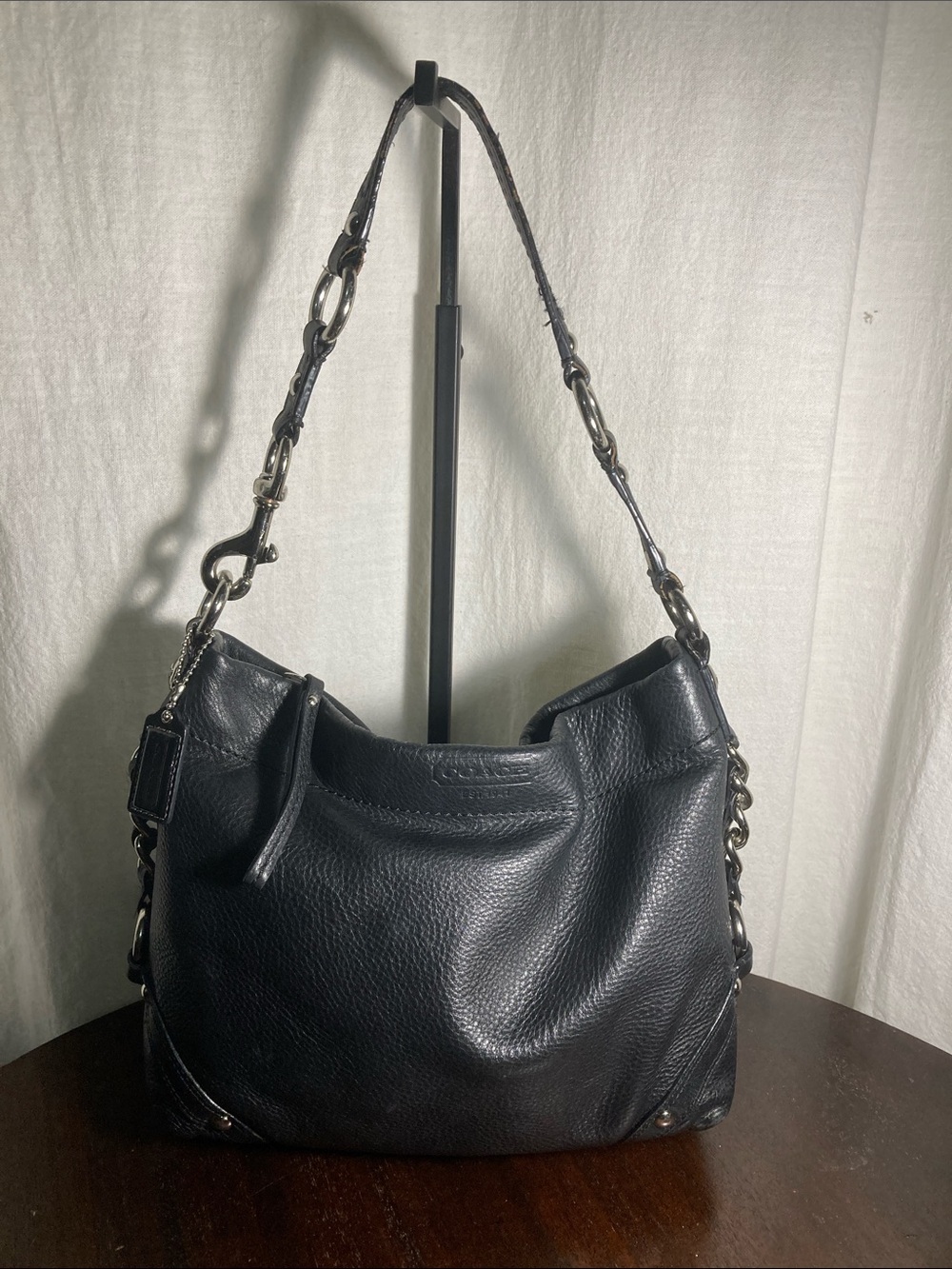 Coach black pebbled leather Carly hobo shoulder bag with silver hardware.